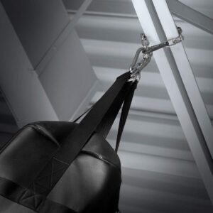 Black punching bag suspended from metal ceiling mount